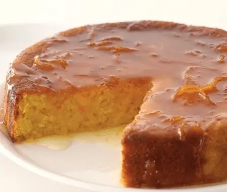Gâteau à l'orange moelleux imbibé de sirop, tranché sur une assiette