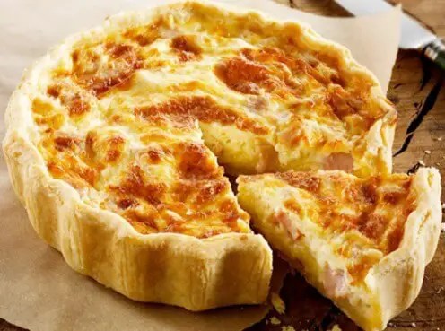Quiche lorraine légère dorée au jambon, une part coupée