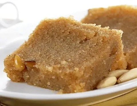 Halva à la semoule démoulé, saupoudré de cannelle et d'amandes