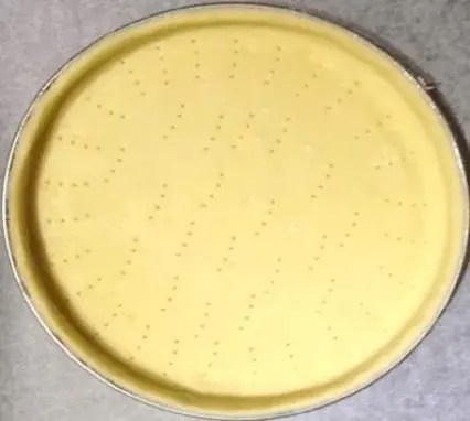 pâte sucrée en boule filmée, prête à être étalée pour un fond de tarte
