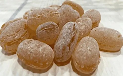 Bonbons au miel maison, pastilles dures et ambrées roulées dans le sucre glace