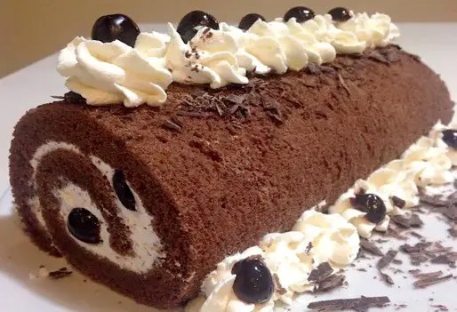 Bûche forêt noire au mascarpone tranchée, décorée de griottes et de copeaux de chocolat