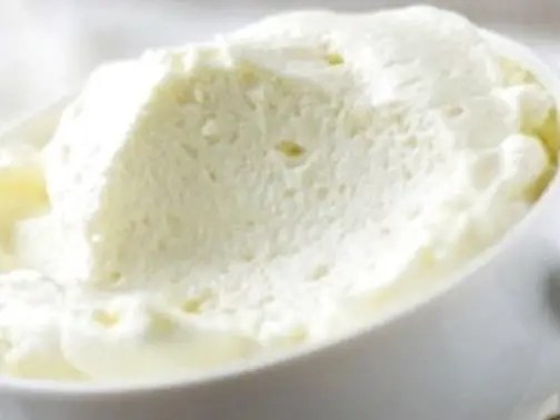 Mousse nuage à la noix de coco en verrine, saupoudrée de coco et copeaux de chocolat