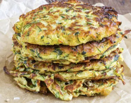 Crêpes de courgettes râpées dorées à la poêle, parsemées de persil frais