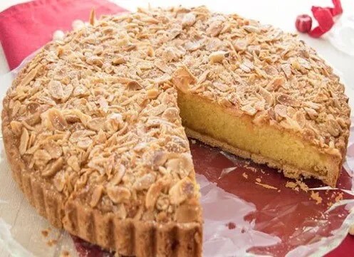 Tarte à la frangipane dorée, part découpée montrant la crème moelleuse sous les amandes effilées