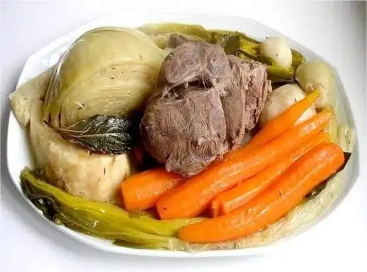 Pot-au-feu grand-mère servi avec bœuf tranché, carottes, poireaux, navets et os à moelle