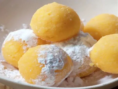 Yemas de Santa Teresa, billes de jaunes d'œufs sucrés roulées dans le sucre glace et posées dans leurs caissettes en papier