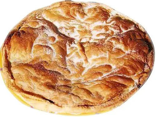 Croustade aux pommes feuilletée et dorée à la cassonade, part découpée montrant les lamelles de pommes
