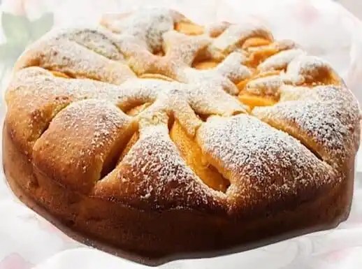 Gâteau aux pêches au sirop décoré de quartiers de pêche