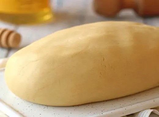 Pâte sablée au miel en disque filmé, prête pour le repos au réfrigérateur