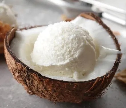 Sorbet coco antillais servi dans une moitié de noix de coco