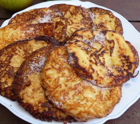 Beignets de Tréguier dorés et caramélisés, garnis de pommes, dans un plat allant au four