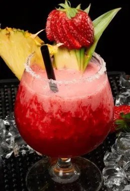 Atomic Freeze, cocktail sans alcool rose aux fraises et à l'ananas, servi dans un grand verre à vin
