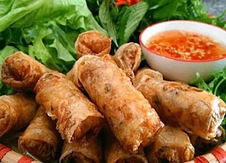 Nems maison dorés servis avec feuilles de laitue, menthe fraîche et sauce au nuoc-mâm