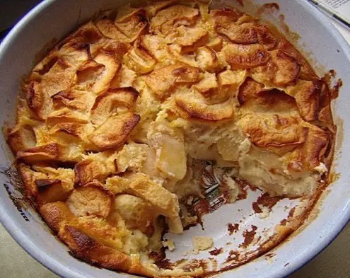 Flaugnarde corrézienne aux pommes dans son plat, surface dorée et tranches de pommes visibles