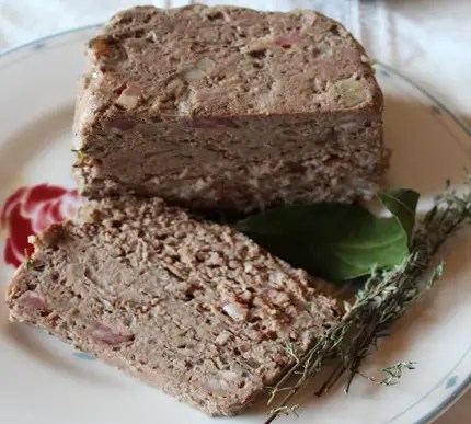 Terrine de campagne maison tranchée, servie avec cornichons et pain