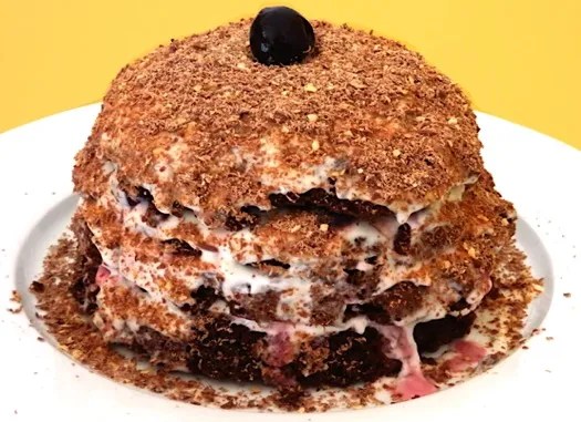 Forêts noires individuelles garnies de crème, de cerises et de chocolat râpé