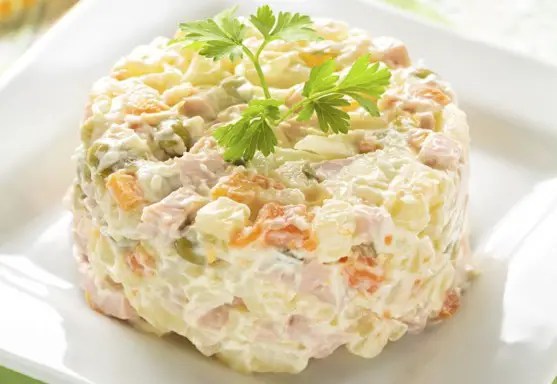 Salade russe Olivier, dés de légumes et jambon liés à la mayonnaise