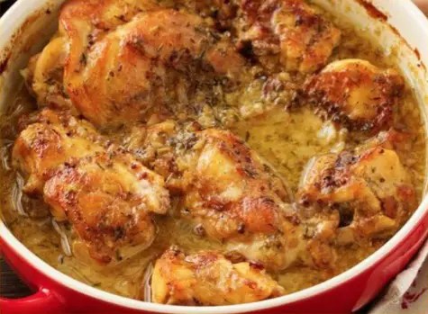 Lapin à la moutarde en morceaux dans un plat, nappé de crème et de persil