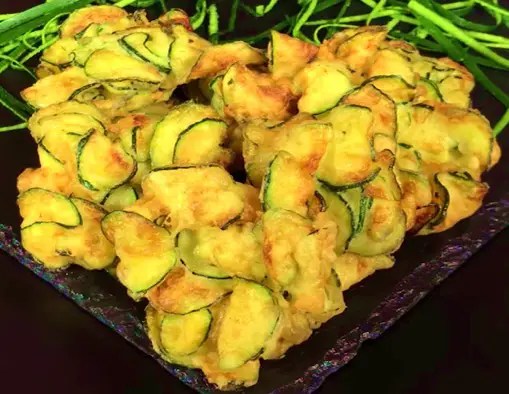 Beignets croustillants de courgettes dorés, égouttés sur une grille