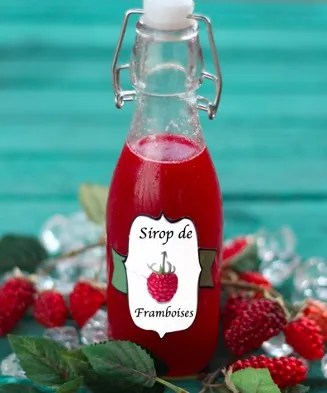 Sirop de framboise maison rouge intense dans une bouteille, avec des framboises fraîches
