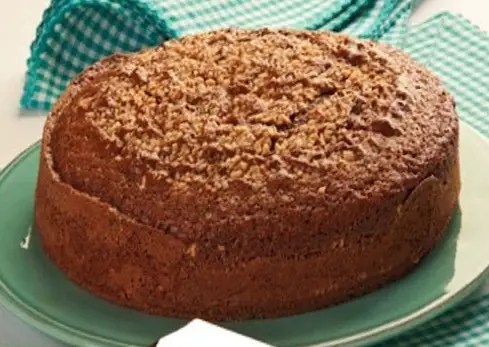 Gâteau moelleux aux noisettes et au cacao, part découpée montrant la mie chocolatée et les éclats de noisettes