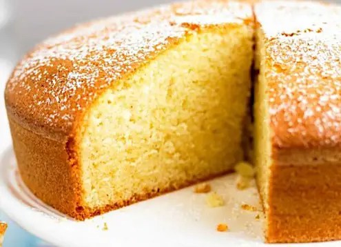 Gâteau 250 g au yaourt moelleux saupoudré de sucre glace, une part découpée