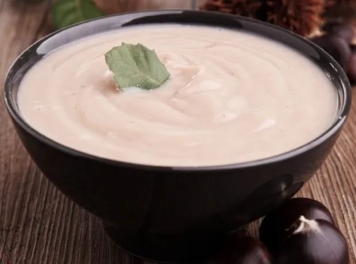 Soupe de châtaignes sèches au lait servie chaude dans un bol, avec du pain grillé