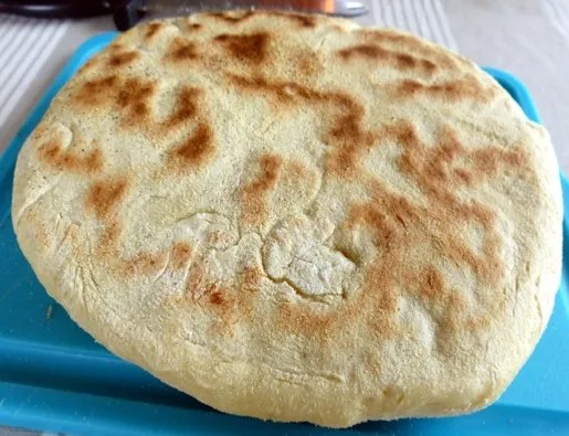 Pain à la semoule à la poêle doré, coupé en parts, mie moelleuse et alvéolée