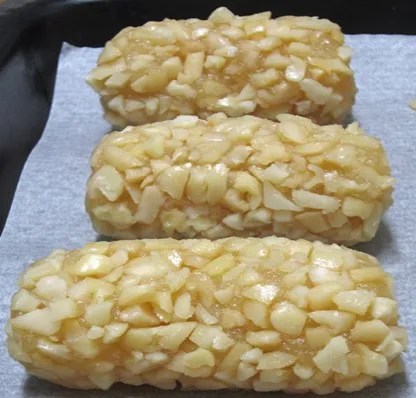 Panellets aux amandes, petits boudins allongés enrobés d'amandes concassées