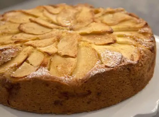 Gâteau aux pommes 1 œuf doré, recouvert de tranches de pommes en rosace et saupoudré de sucre glace