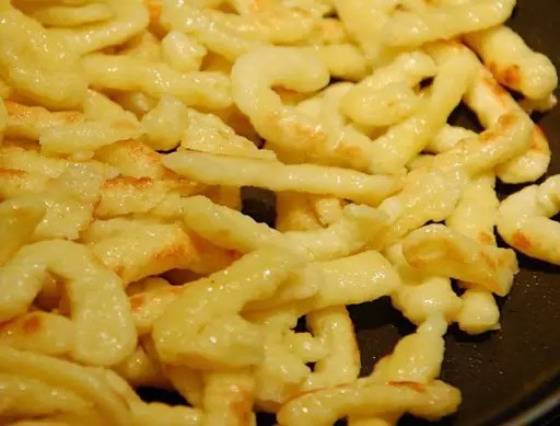 Spätzle maison dorées au beurre, pâtes fraîches alsaciennes servies dans un plat
