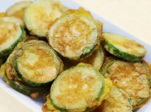 Beignets de courgettes à l’eau pétillante dorés, égouttés sur une grille