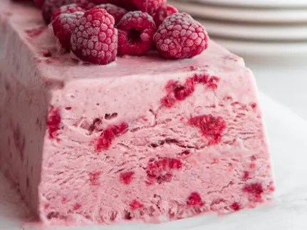 Parfait à la framboise démoulé, décoré de framboises fraîches