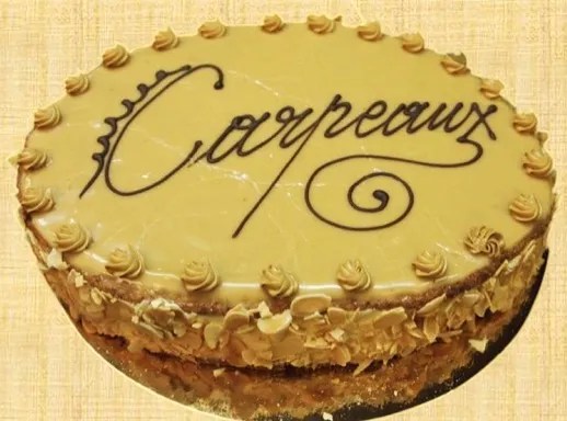 Gâteau Carpeaux ovale au fondant au café, décoré d'amandes effilées et de marrons glacés