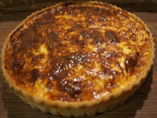 Quiche auvergnate dorée au cantal, à la fourme d'Ambert et au jambon cru, une part découpée