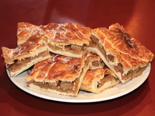 Pâté aux pommes doré à la sortie du four, une part coupée laissant voir les tranches de pommes