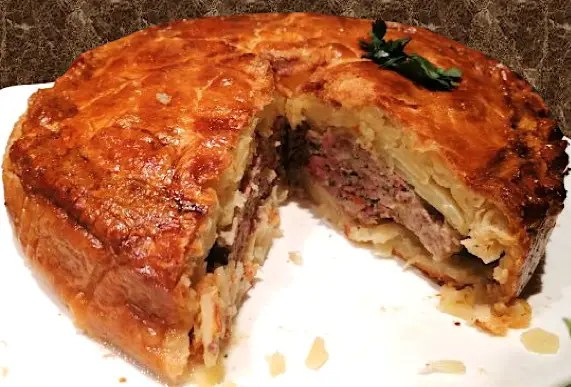 Pâté de pommes de terre limousin doré, part coupée montrant les couches de pommes de terre et de chair à saucisse