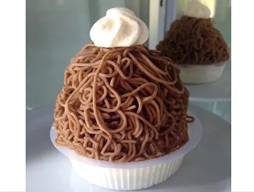 Torche aux marrons alsacienne, meringue couverte de chantilly et de vermicelles de purée de marrons dans une assiette