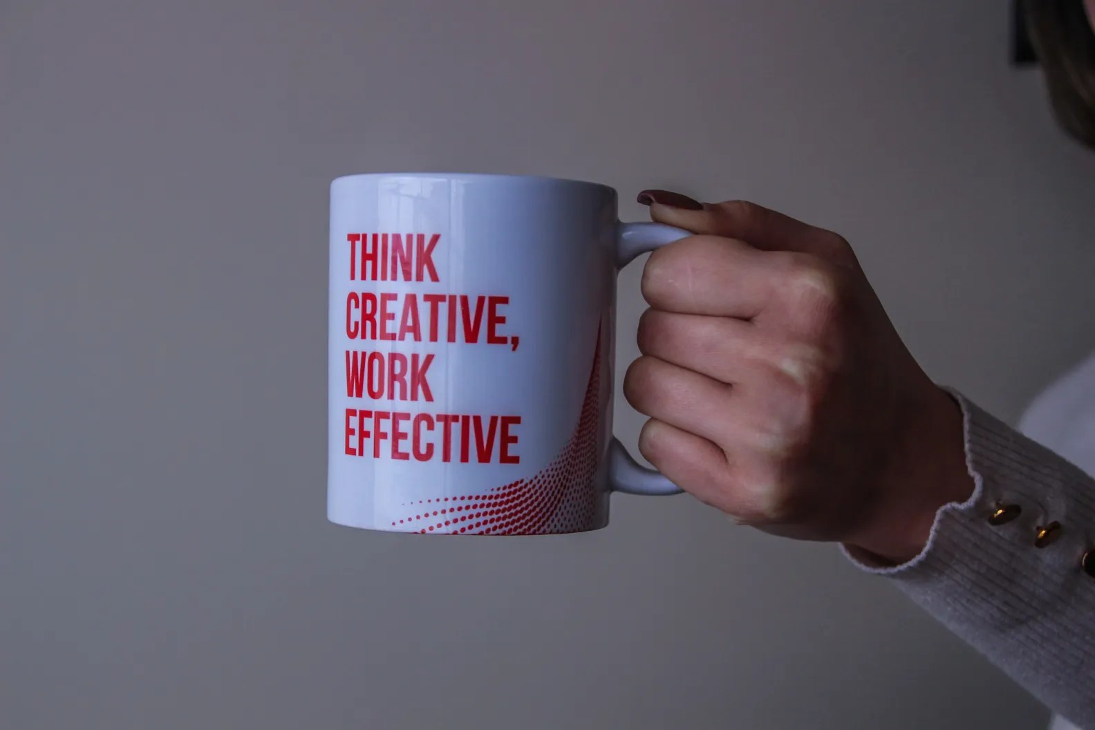A girl holding a cup with Marketing quote