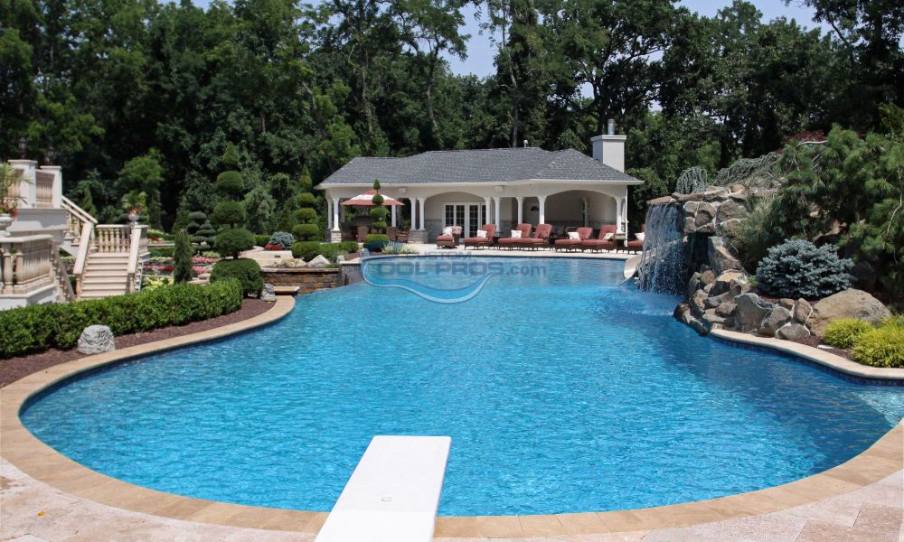 inground gunite swmming pool with vanishing edge with pavilion and sitting lounge chairs