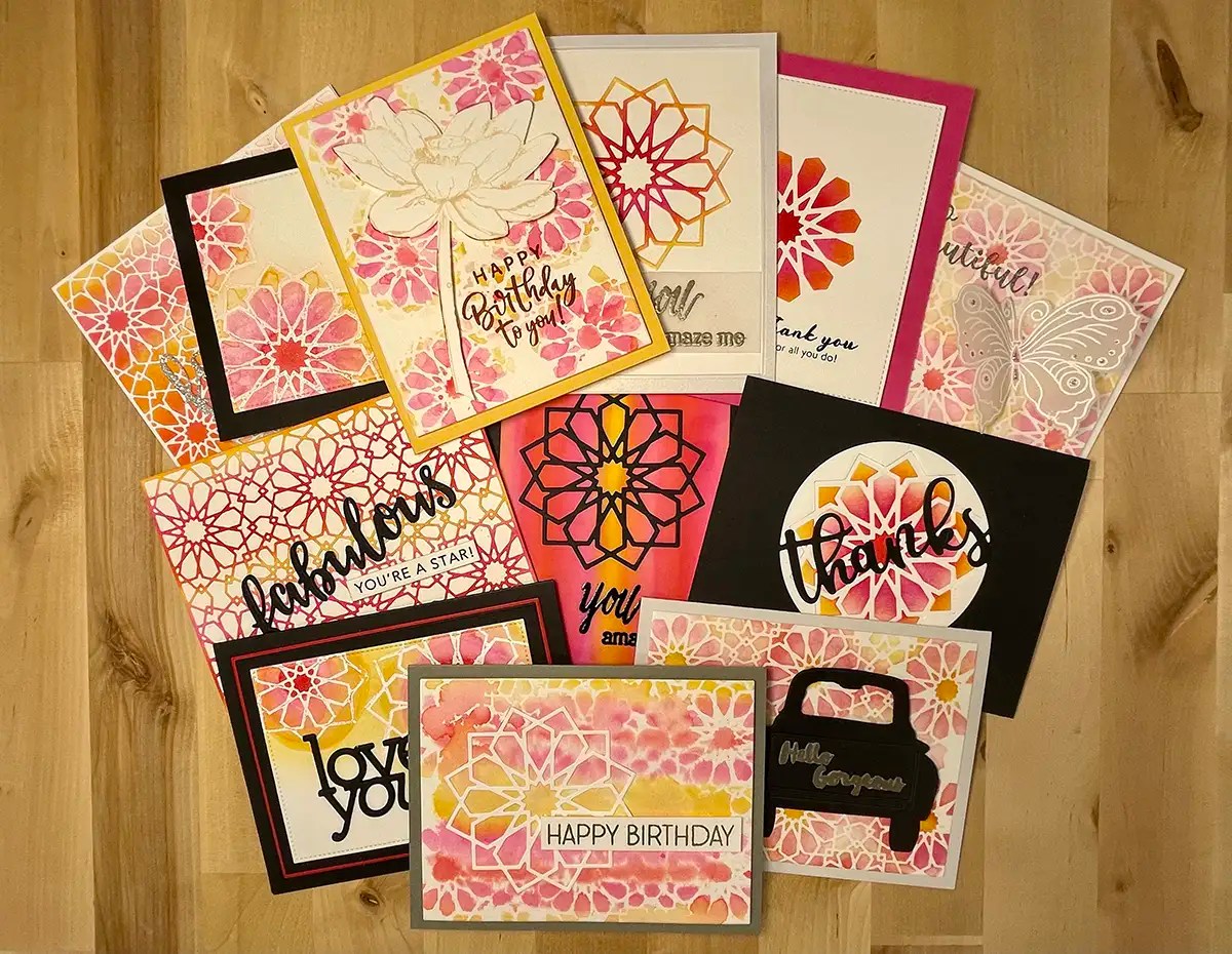 A jaw-dropping collection of handmade greeting cards with floral designs and messages such as "Happy Birthday," "Thank You," and "You're a Star" spread out on a wooden surface, perfect for any cards set you want to create.