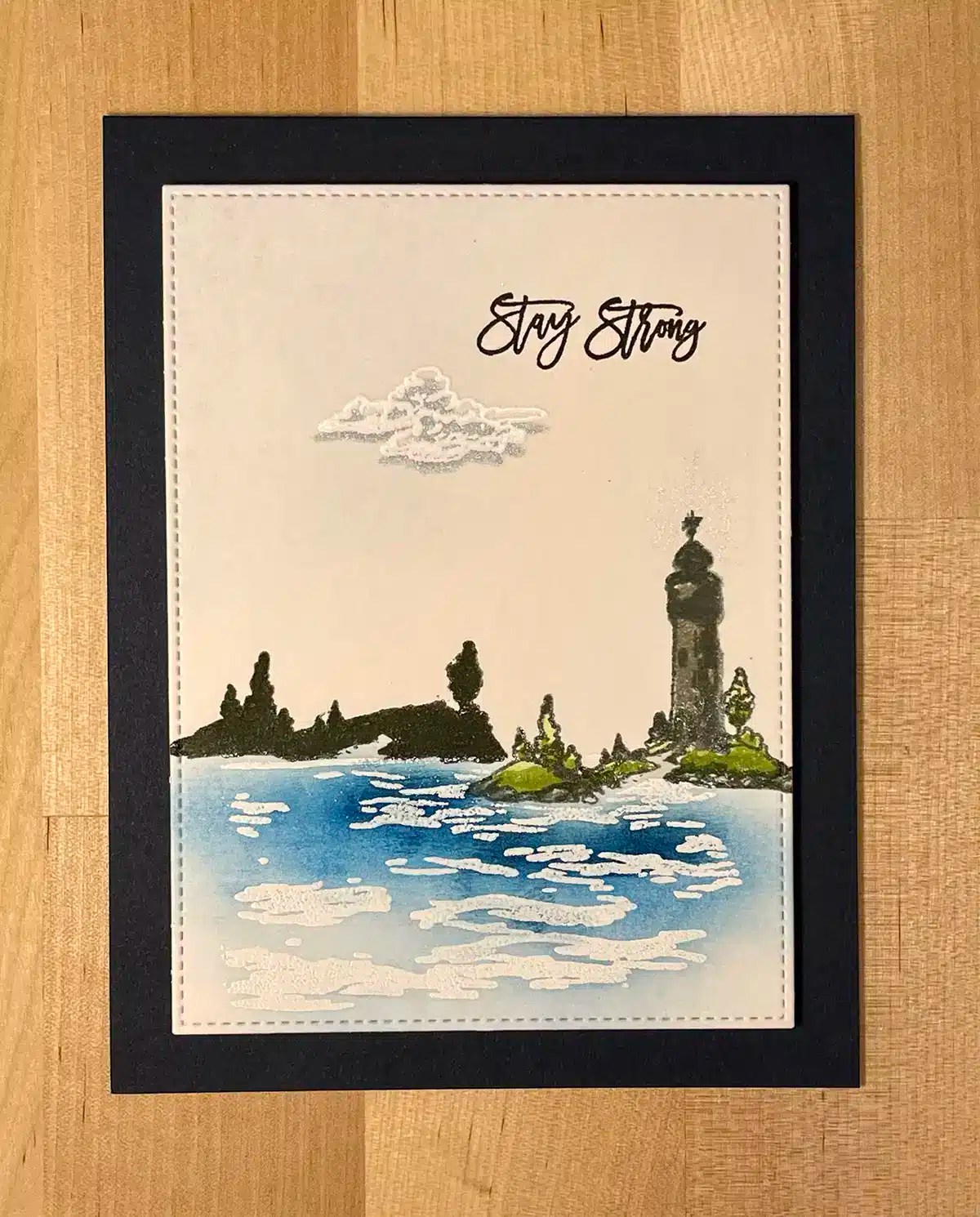 A handmade Mood Card features a lighthouse by the sea with trees and an island in the background. The words "Stay Strong" are written in cursive at the top.