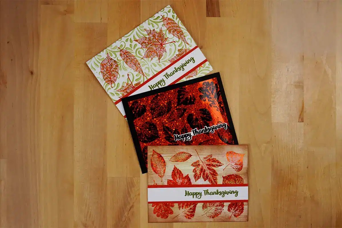 Three thanksgiving cards on a wooden table.