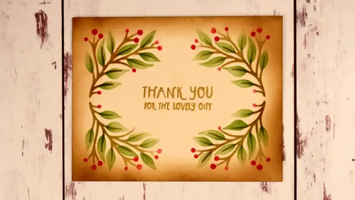 A stenciled thank you card with greenery and red berries