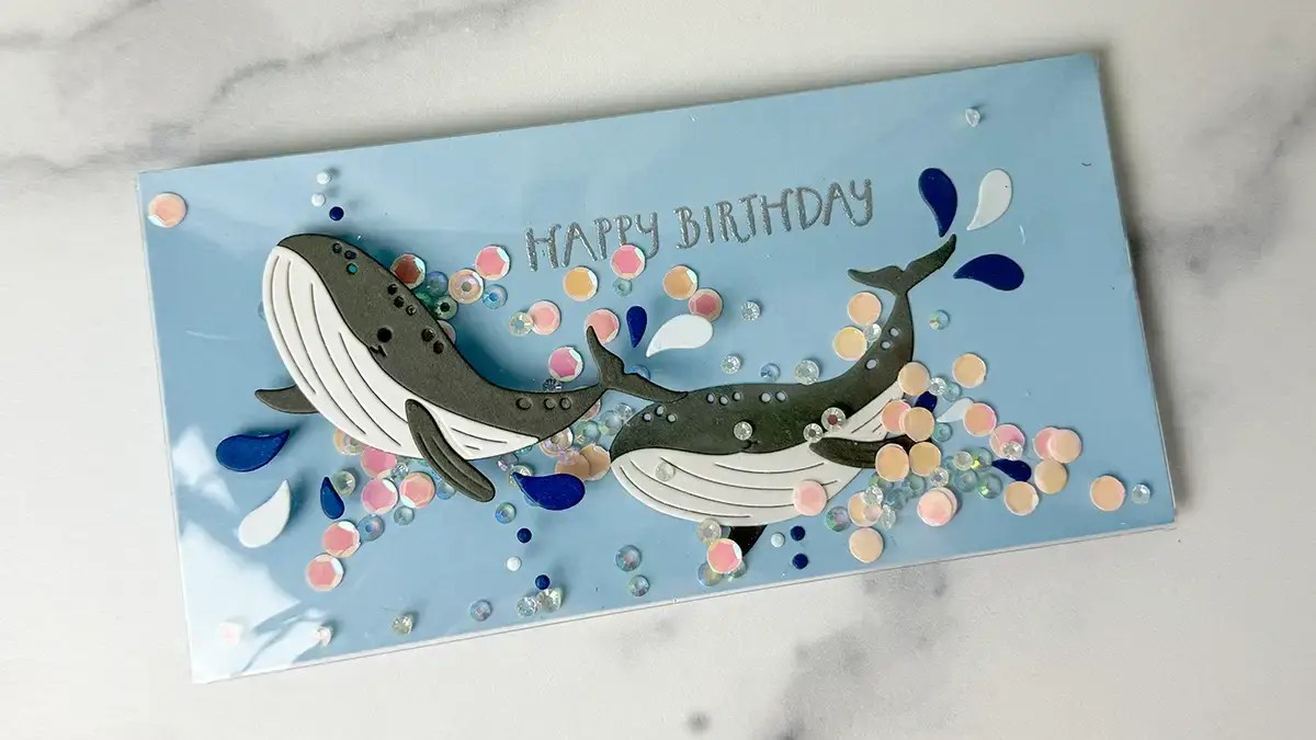 A birthday card with two whales on it.