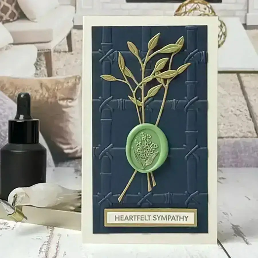 A card with a wax seal and sprigs on it.