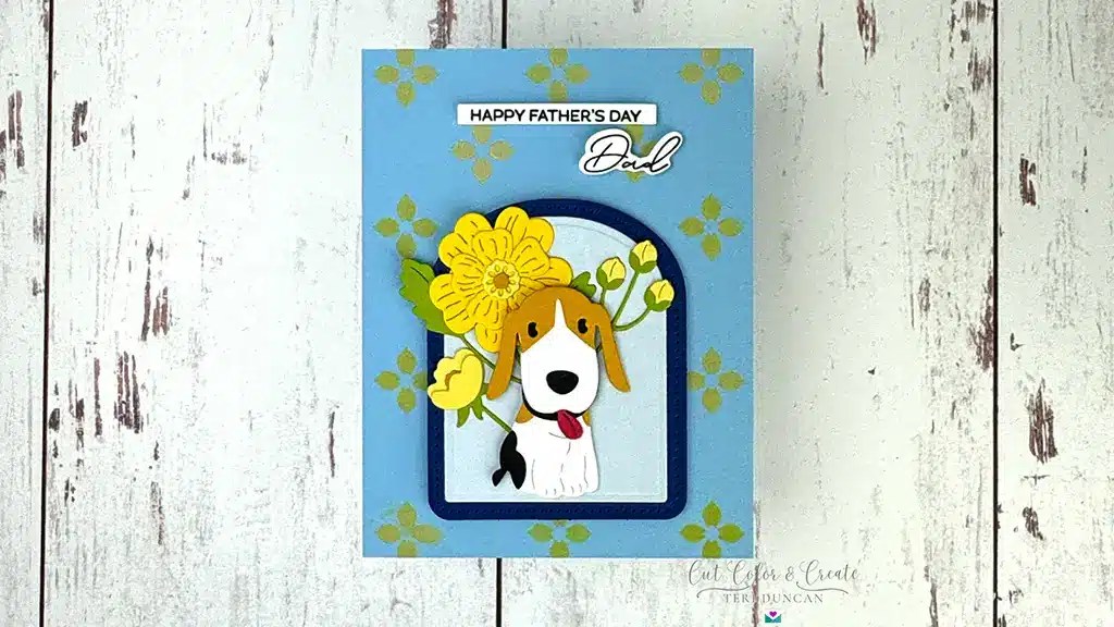 Father's Day card featuring a cartoon dog and yellow flower on a blue background, crafted with charm from the Spellbinders' March '25 Kits. Text reads "Happy Father's Day Dad.