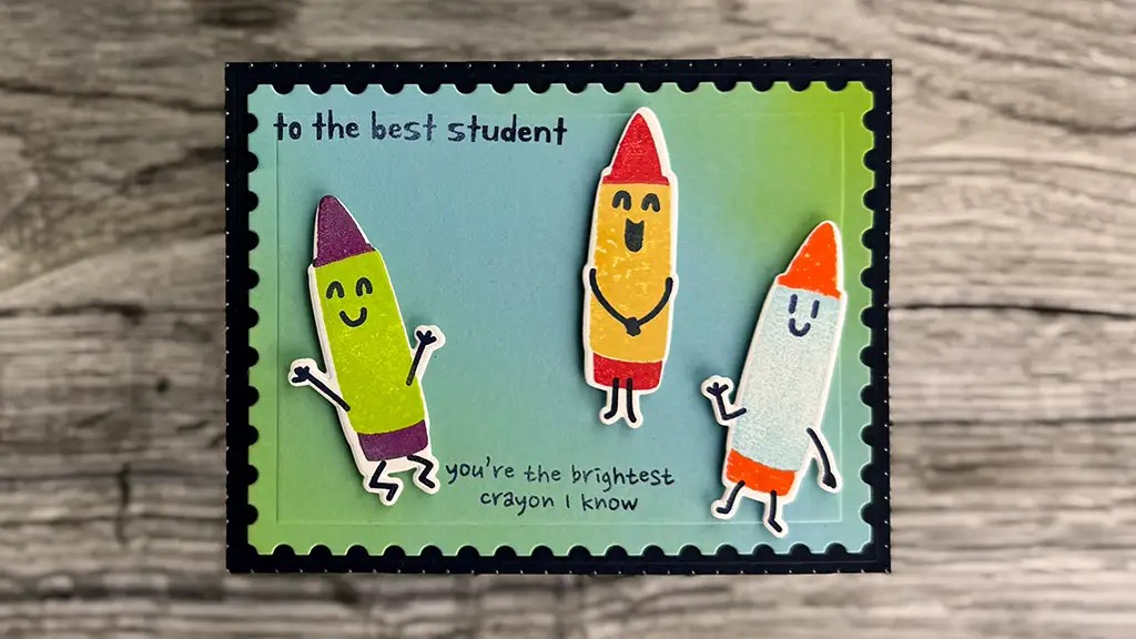 A handmade card for card making, featuring three cartoon crayons and messages "to the best student" and "you're the brightest crayon I know," on a blue and green background. Perfect addition to your May '25 Club Kits collection.