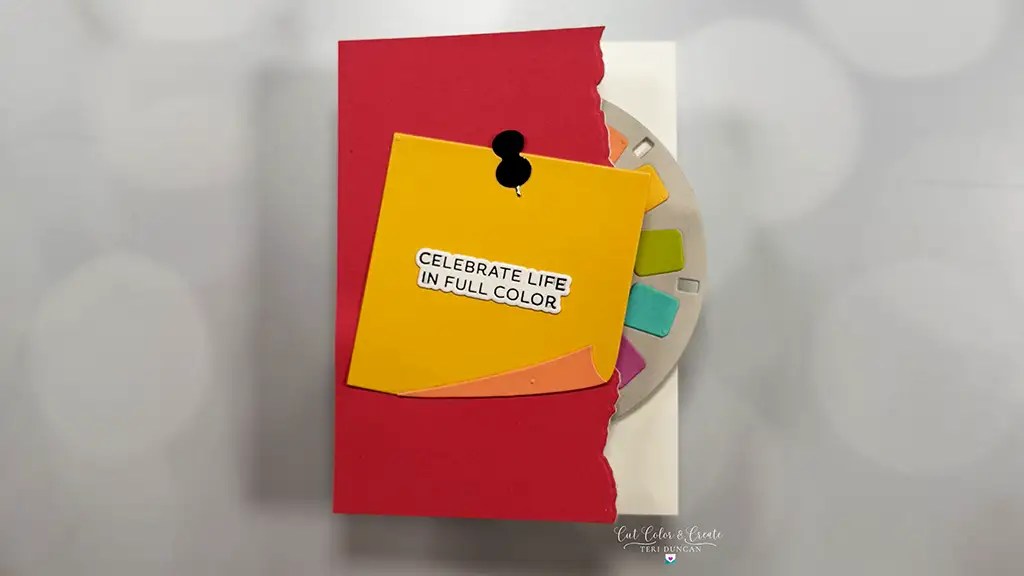 A pink card with a torn edge features a yellow note pinned on it, reading "Celebrate life in full color," with a color palette partially visible—perfect inspiration for your next cardmaking ideas. Created using products from the Take A Note Collection.